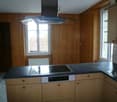 kitchen with stove, sink, cabinets, dishwasher, white tiles, wooden wall