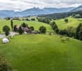 House with outbuildings, located on a hillside with a wide view of the mountains, garage