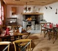 Wooden floor, wooden furniture, fireplace, dining tables, chairs, napkins, wine glasses
