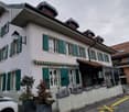 3 story house, white exterior, green shutters, awnings, plants, street view