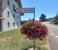 white building, red roof, street sign, flowers, road