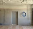 empty room, concrete walls, wooden floor, door, window, blue hoses
