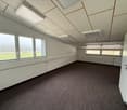 empty room with large windows, white walls, ceiling with recessed lights, and carpet flooring