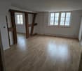 Hardwood floor, wooden beams, windows, empty room