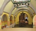yellow walls, arched ceiling, chandelier, tables and chairs, spotlights