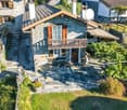 2 story stone house, grey roof, balconies, stone walk ways