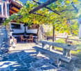 Garden: stone bench, table, chairs, plants, balcony, wall, door