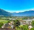 Aerial view of mountains, green fields, lake, and houses