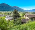 Green mountains, valley, houses, and trees.