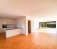 modern kitchen with island, white cabinets, granite countertop, built-in oven, large windows, wooden floor