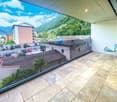 Balcony with panoramic view, glass railing, floored with stone tiles, outdoor chair