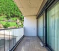 Terrace with tiled floor, full glass railing, sliding glass doors.