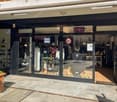 Commercial shop front, glass entrance doors, open sign, illuminated, large glass windows, display items