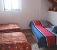 2 single beds, wooden floor, window, rug, wooden ceiling
