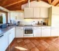 modern kitchen with white cabinets, granite countertops, stainless steel appliances, tiled floor, large window