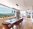Dining room with large windows, wooden table, brown chairs, pendant lights, view of mountains