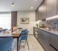 Dining table set for 6, modern cabinets, sink with faucet, countertop with appliances, gas stove