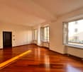 empty room, wooden floor, white walls, large windows, radiators, door