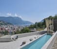 Long swimming pool, lounge chairs, outdoor table, stairs leading up