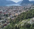 Aerial view of city surrounded by mountains and water body