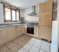 Spacious kitchen with wooden cabinets, granite countertops, stainless steel appliances including a dishwasher, and tiled flooring.