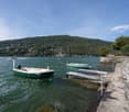 2 boats anchored to pier, lake, mountains in the background
