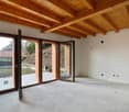 Wooden beams on ceiling, double glass doors, sloped outdoor area