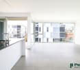 modern kitchen with large windows, balcony, stainless steel sink, black countertop, white cabinets