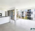 modern kitchen with white cabinets, black countertops, large windows, balcony