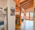 wooden ceiling, wooden floor, wooden shelf, glass doors, wooden ladder with hanging items, paintings on the wall