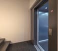 elevator door, carpeted floor, white wall, gray door, light inside elevator