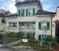 3 story house, white exterior, green shutters, brown roof, balcony, garden, fence