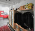 corridor with shelves, closet, rack, kitchen with red cupboards and kitchen island