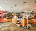 interior of a shop with checkered floor, round open shelves with a variety of products and a wooden counter