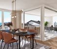 Spacious open-plan living and dining area with large windows offering a scenic view, hardwood floors, modern dining table and chairs, comfortable sofa, and a balcony or terrace accessible through the sliding glass doors.