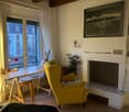 yellow armchair, wooden desk, lamp, fireplace, view to the street