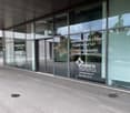 Modern building with glass facade, entrance doors, and informational signage