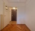 empty hallway, wooden floor, radiator, doorway, brown interior door