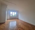 wooden parquet flooring, white walls, large window, white radiator, power outlet, hallway