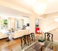 glass coffee table, leather chairs, white couches, balcony, modern chandelier, plants, stairs