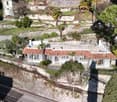 Terraced house, stone walls, red roof, chimneys, multiple windows, front yard, terrace