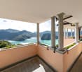 balcony with lake view, columns, plants, tiled floor