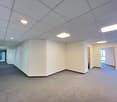 long and narrow hallway, grey floor, white ceiling with recessed lights, blank walls
