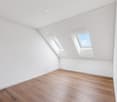 empty room with wood floor, white walls, two roof windows