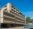 Building has 4 floors, concrete construction, glass windows, large windows