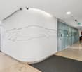 white wall with abstract design, glass wall, tiled floor, glass doors, surveillance cameras