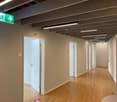 empty hallway, hardwood flooring, white walls, emergency exit signs