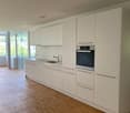 white kitchen, wooden floors, glass door, oven, sink, faucet, cabinets