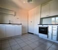 modern kitchen with white cabinetry, black countertops, silver appliance, stainless steel drawer, sink, faucet, oven
