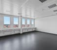 large windows, ceiling mounted security cameras, modern design, grey flooring, white walls